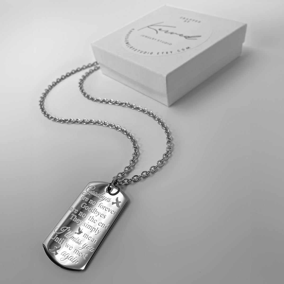Sister memorial dog tag necklace engraved with a personalized remembrance message displayed next to a gift box