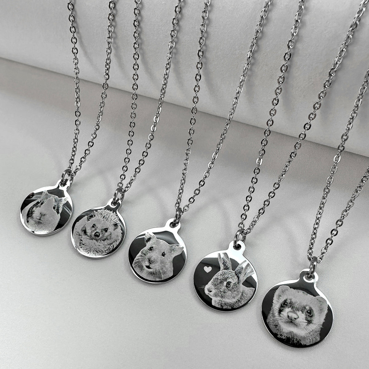 Five silver chain necklaces with round custom pet portrait pendants, displayed on a light gray background.