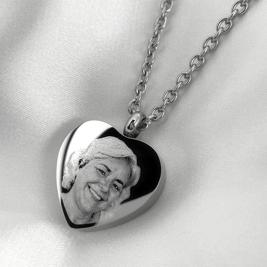 Close-up of a personalized heart urn necklace engraved with a custom portrait.