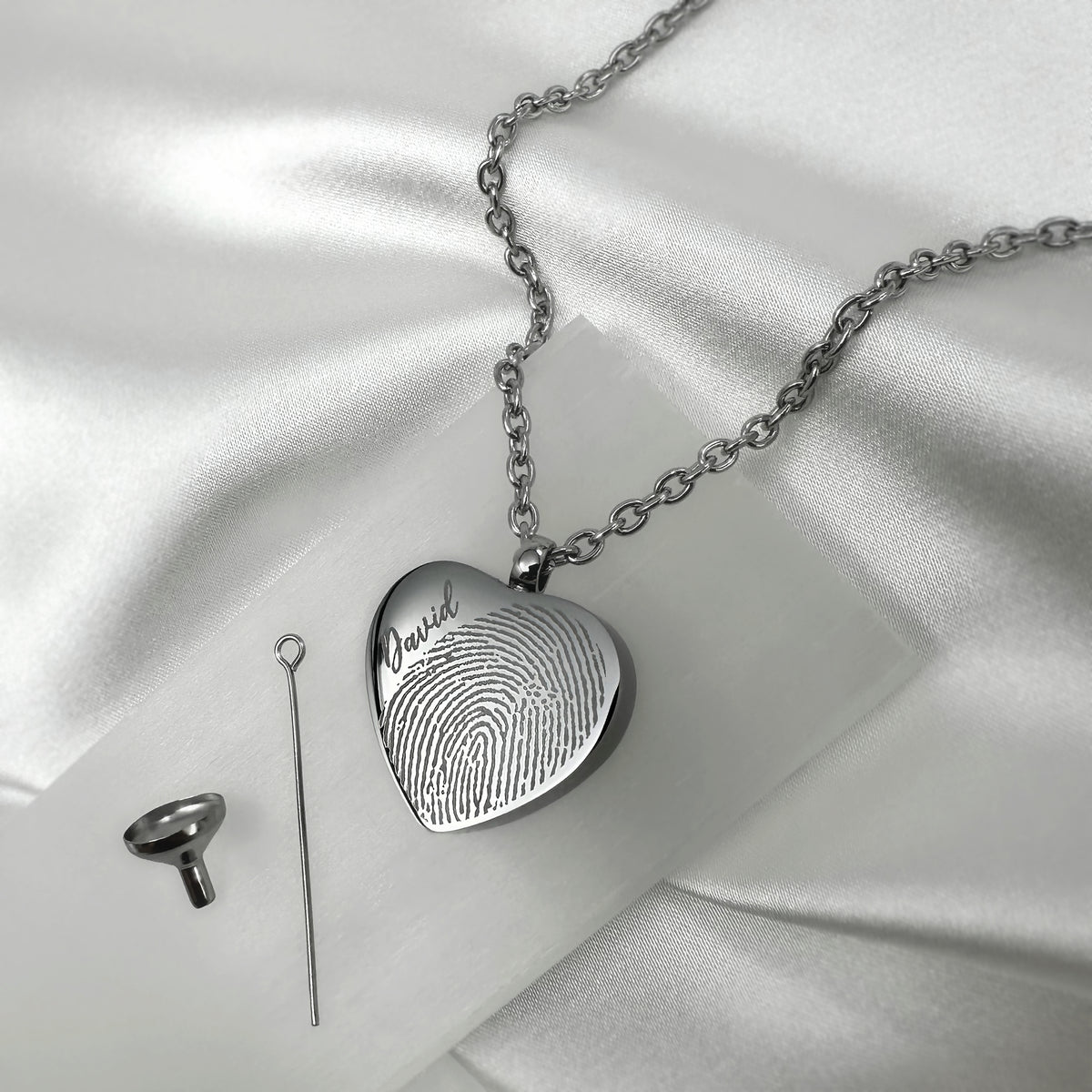 Back of a heart-shaped cremation urn necklace engraved with a custom fingerprint.