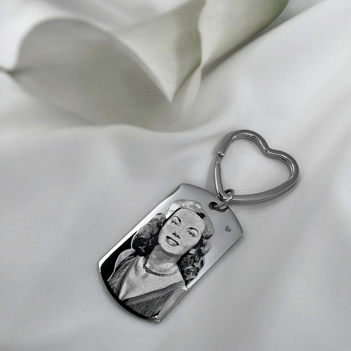 Personalized memorial photo dog tag keychain with heart-shaped keyring and custom portrait engraving in a styled lifestyle setting