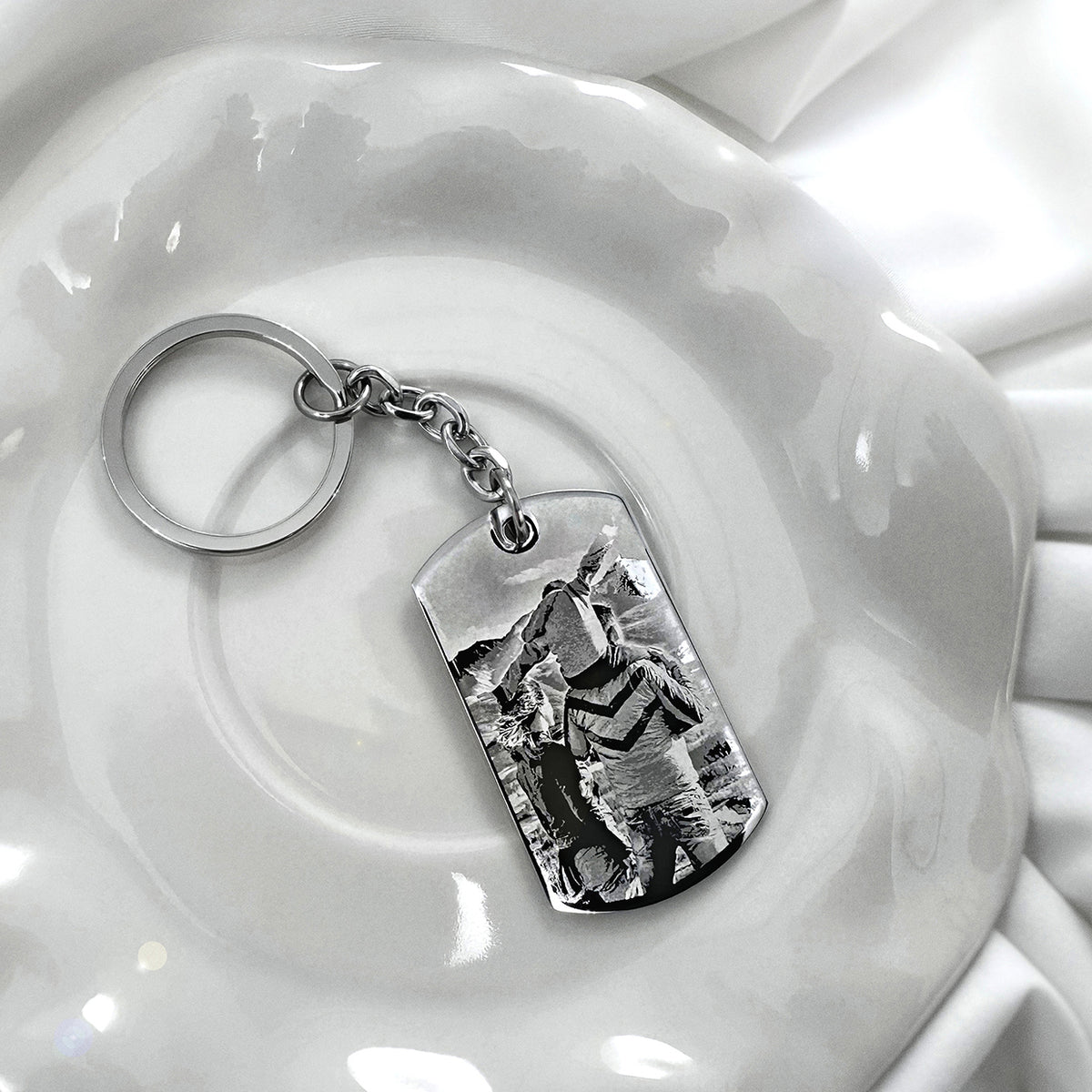 Personalized memorial photo dog tag keychain with round keyring displayed on a white dish in a soft lifestyle setting