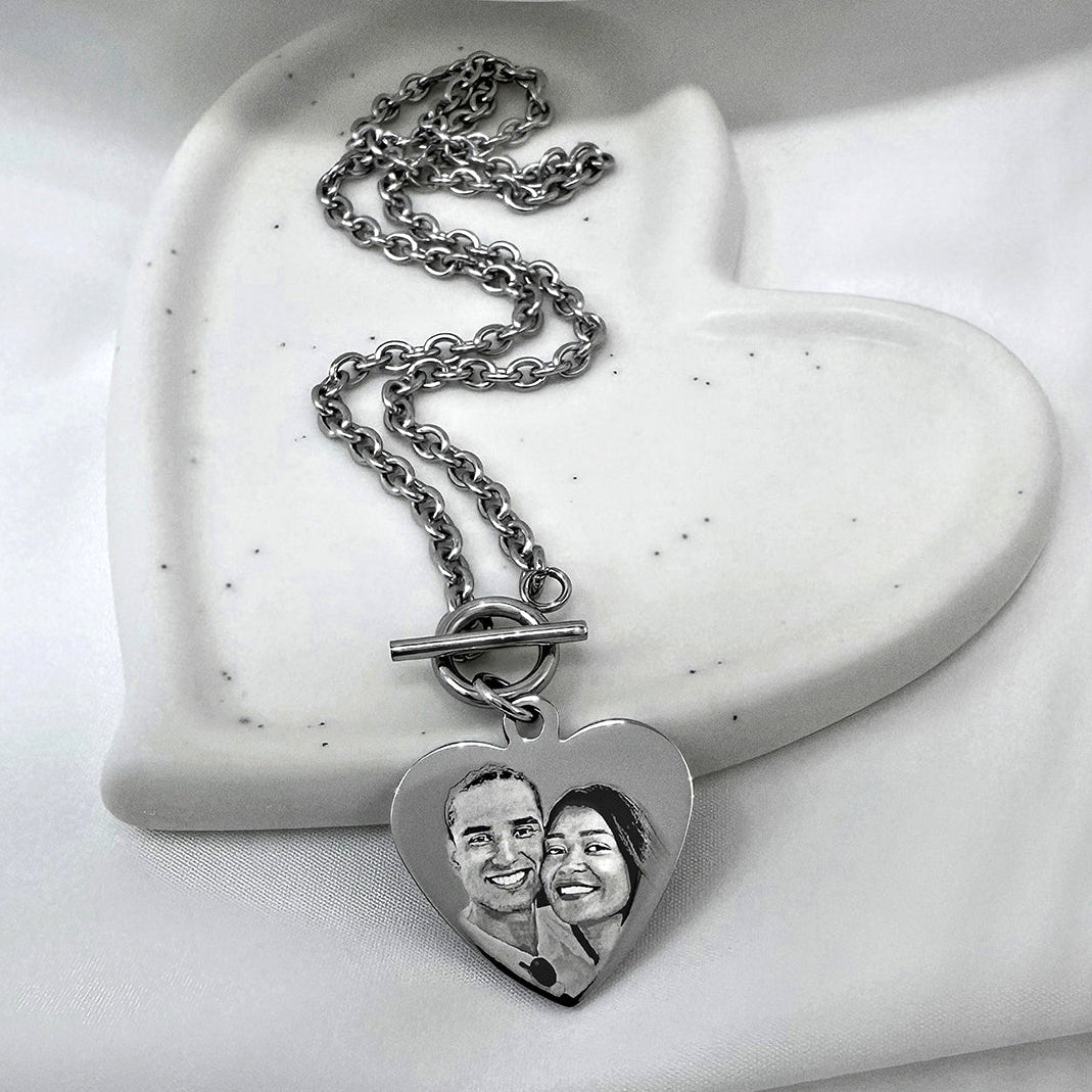 A silver heart-shaped pendant toggle clasp necklace with a custom photo engraving of a couple.
