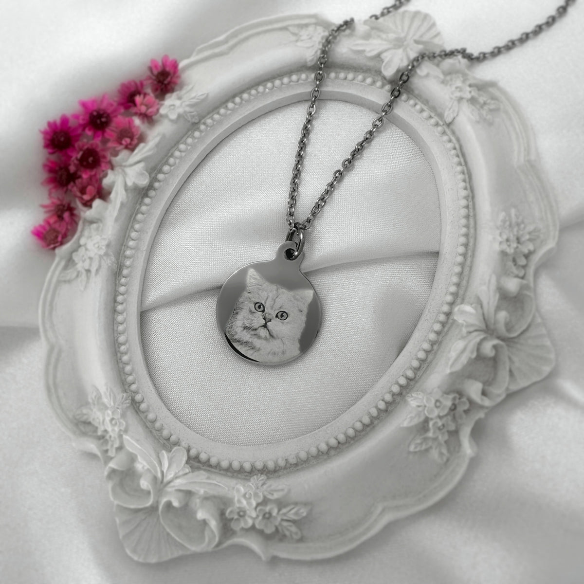 A silver round pendant necklace with a custom engraved cat portrait.