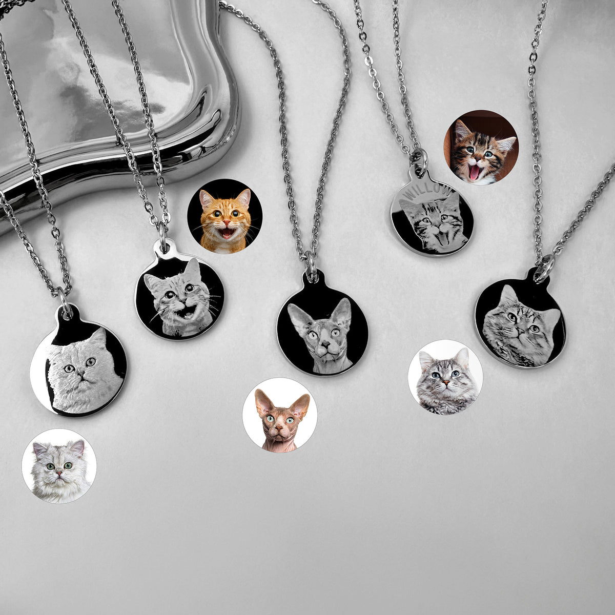Several silver necklace pendants with personalized round cat portrait charms.