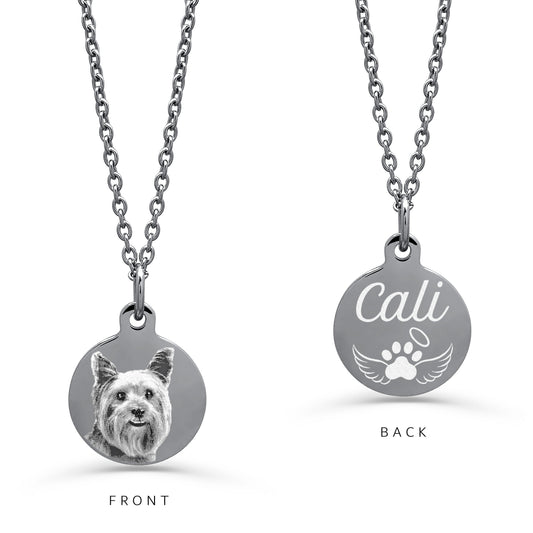 A silver round pendant necklace on a white background, labeled FRONT and BACK. The front shows a personalized photo of a small dog, and the back shows a custom name in script above a paw print with wings.