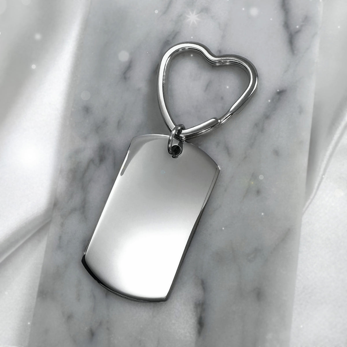 Blank polished dog tag keychain with heart-shaped keyring displayed on marble