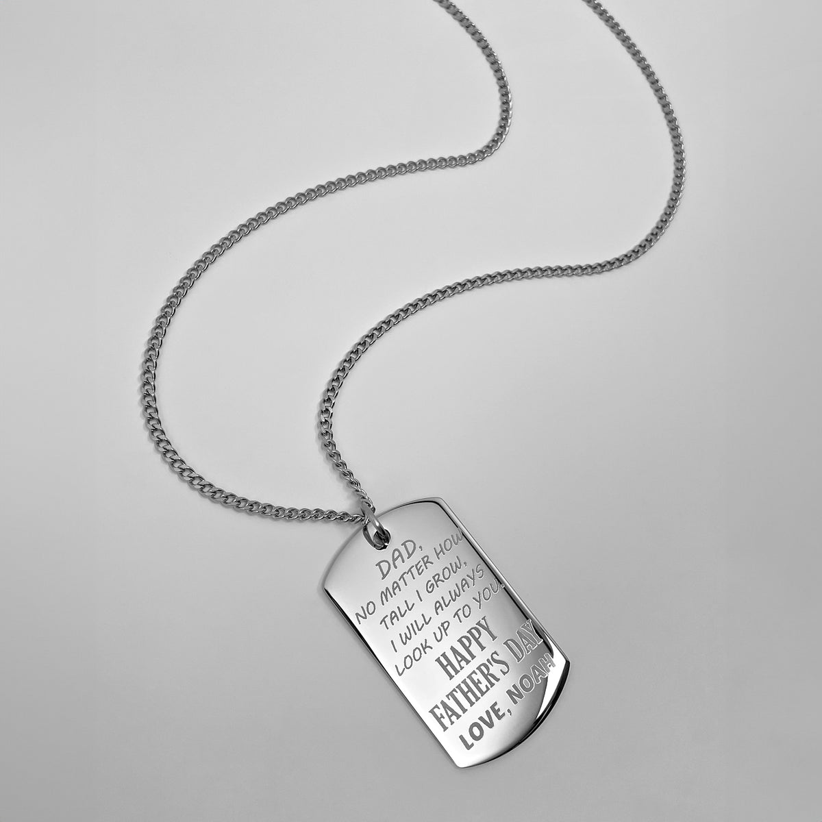 Personalized Father’s Day dog tag necklace engraved with a custom message “No matter how tall I grow, I will always look up to you”