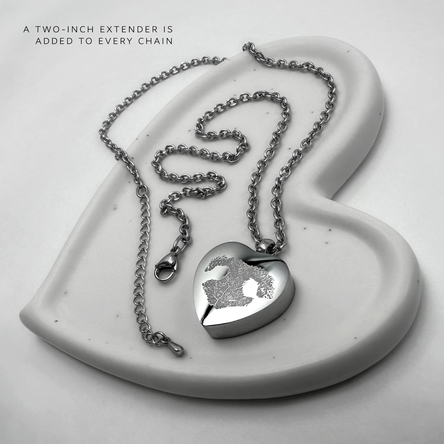 Personalized heart-shaped pet cremation urn necklace with photo engraving, silver chain, lobster clasp, and two-inch extender.