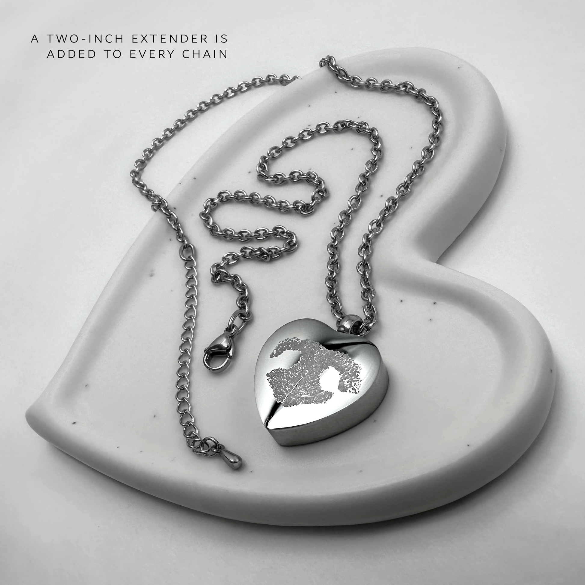 Personalized heart-shaped pet cremation urn necklace with photo engraving, silver chain, lobster clasp, and two-inch extender.