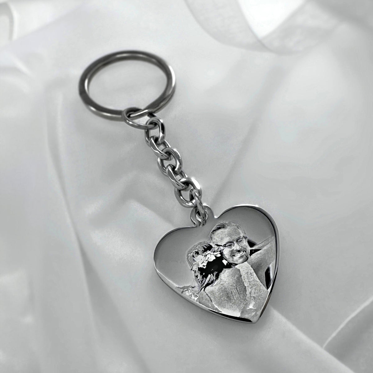 Custom father daughter wedding photo engraved heart keychain displayed on soft satin