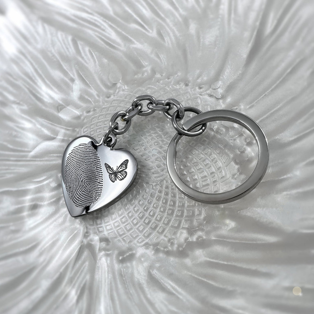 Personalized memorial heart keychain engraved with custom fingerprint and a butterfly design