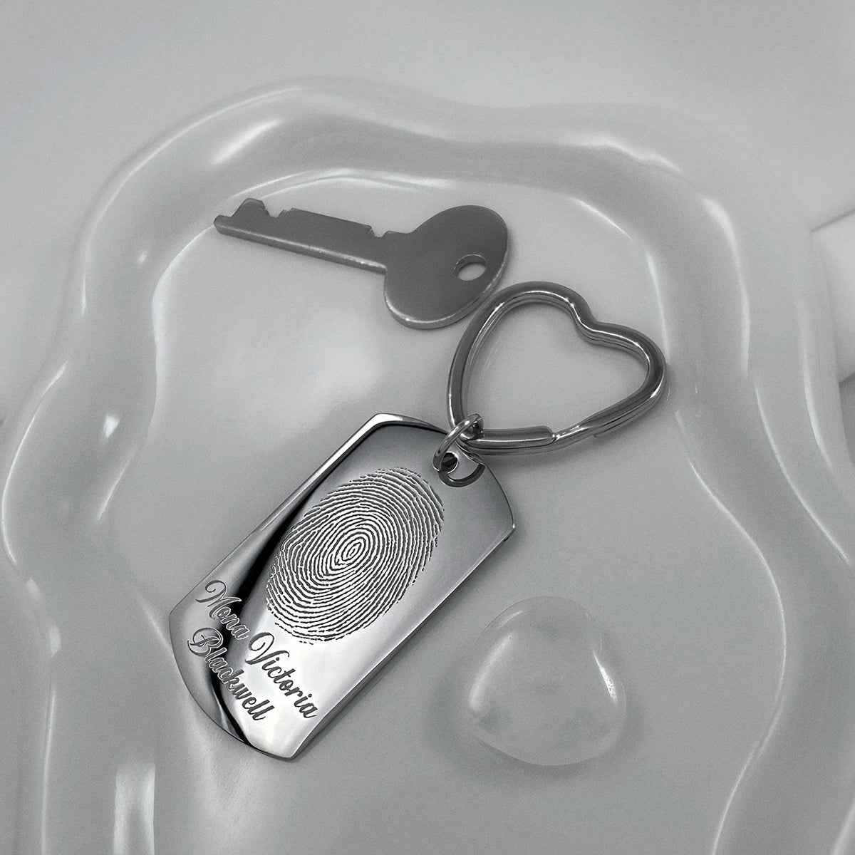 Mom fingerprint memorial dog tag keychain with heart-shaped keyring displayed on a white dish, featuring custom fingerprint and personalized name engraving