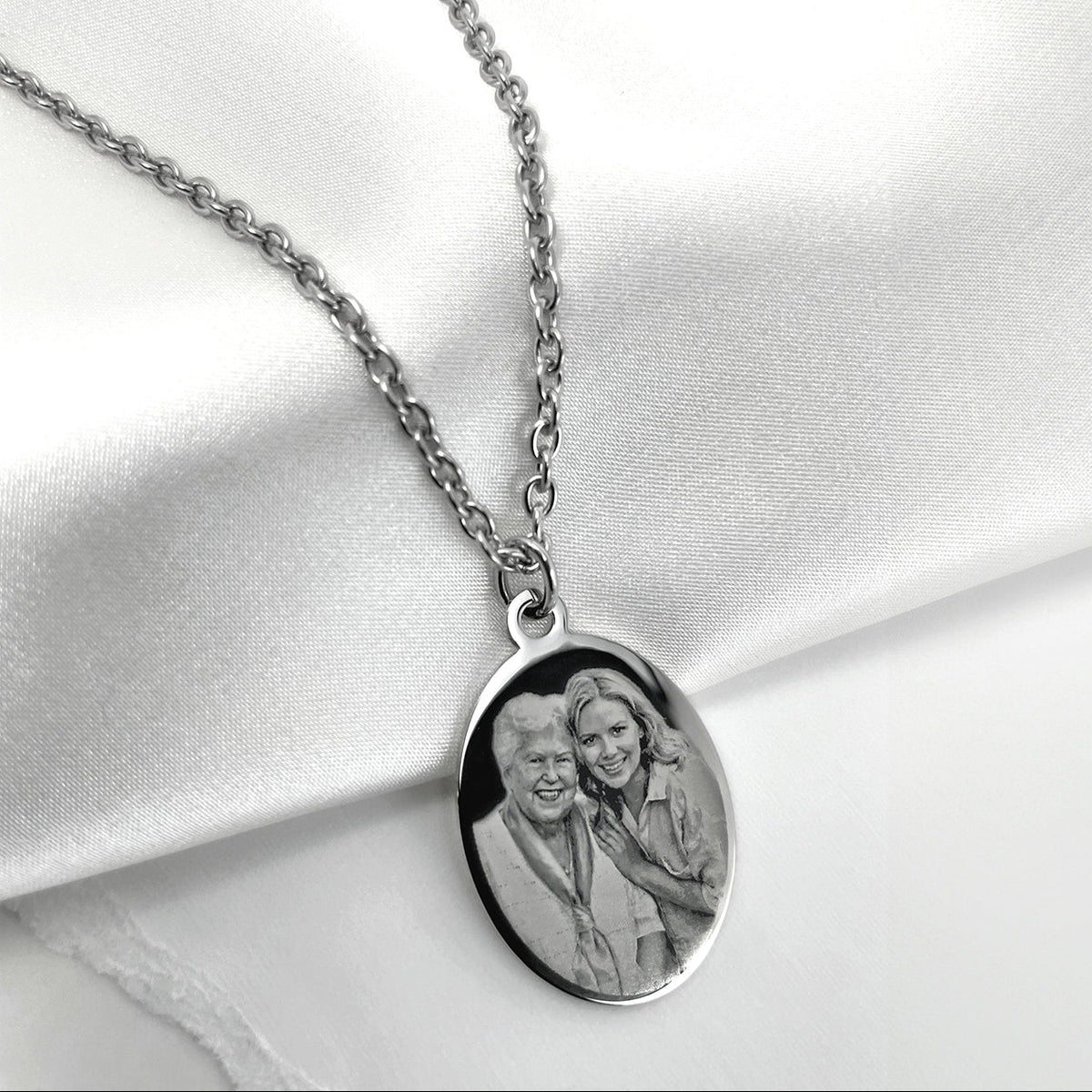 Personalized Grandma photo oval pendant necklace displayed on soft satin