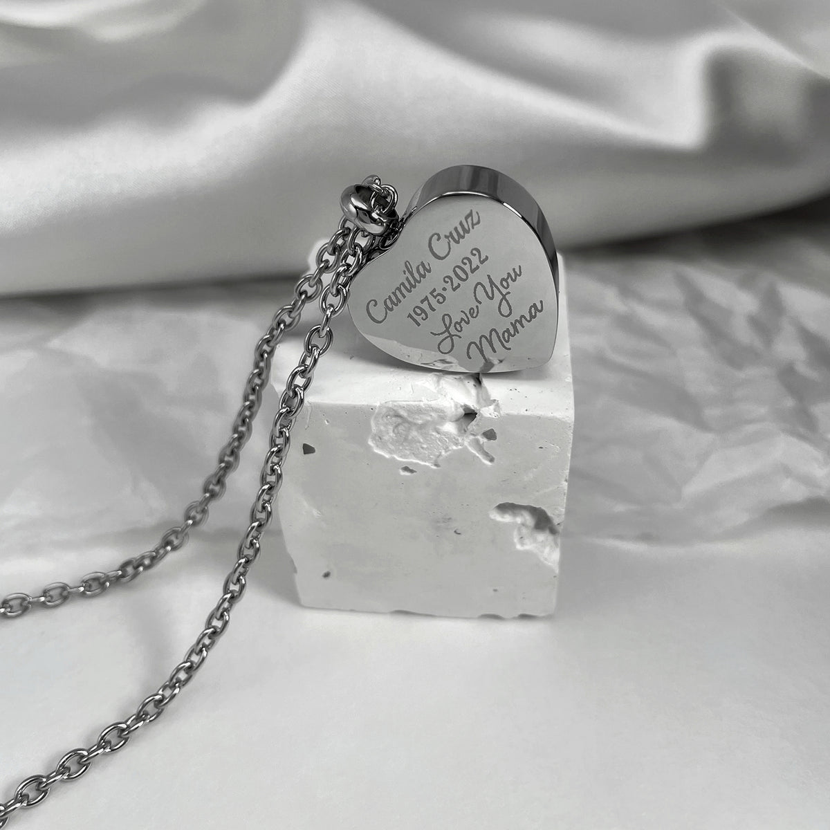 Back of a heart urn necklace engraved with personalized memorial wording and displayed on chain