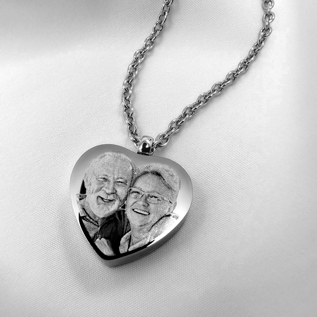 Heart urn necklace engraved with a couple’s portrait on a silver heart pendant with chain