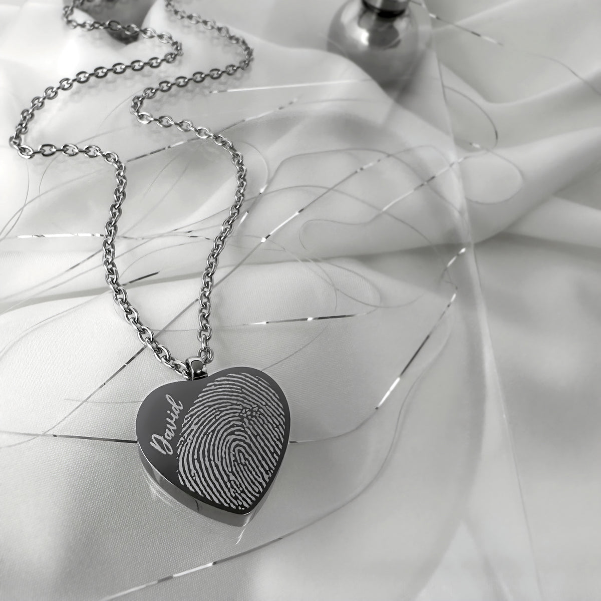 Fingerprint engraved heart urn necklace styled on soft satin with silver chain