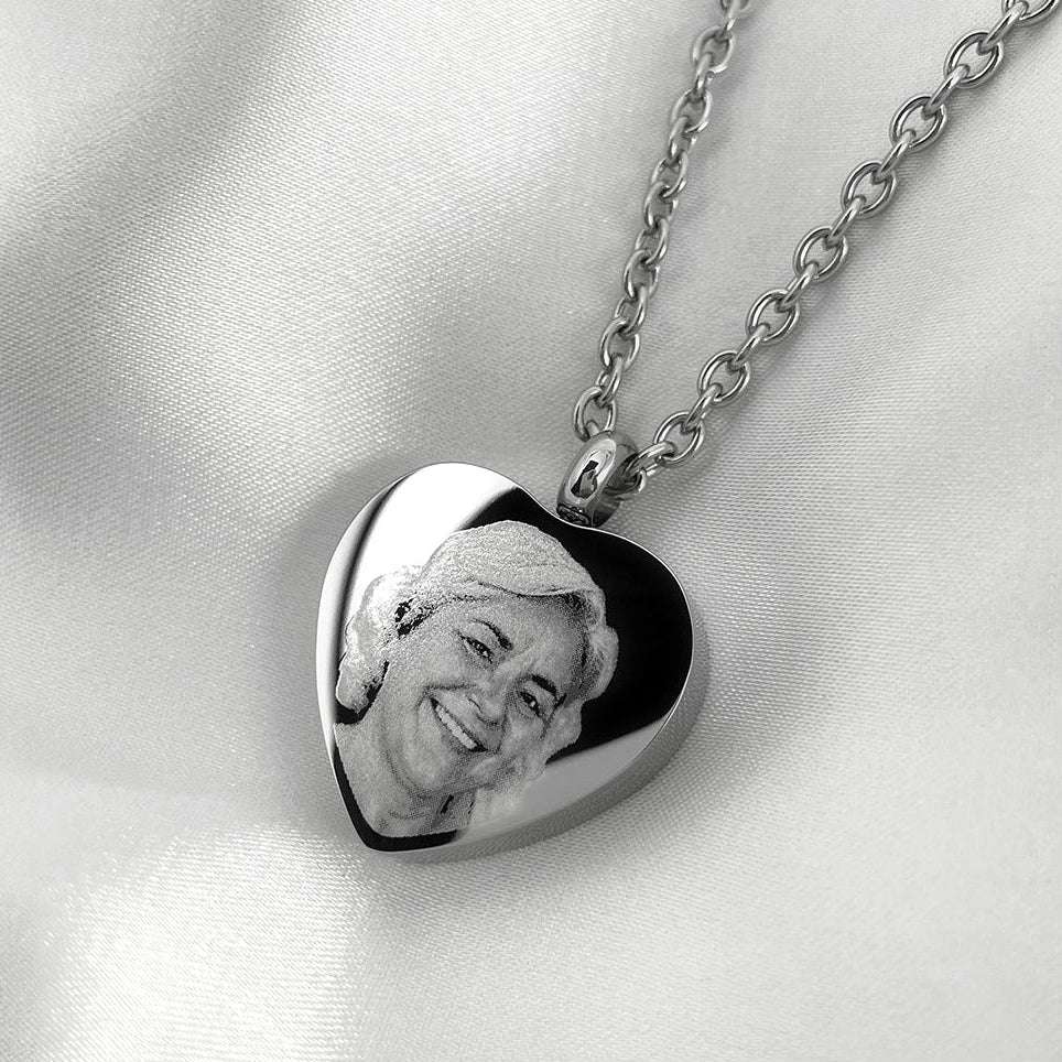 Personalized heart urn necklace with engraved woman’s portrait displayed with silver chain