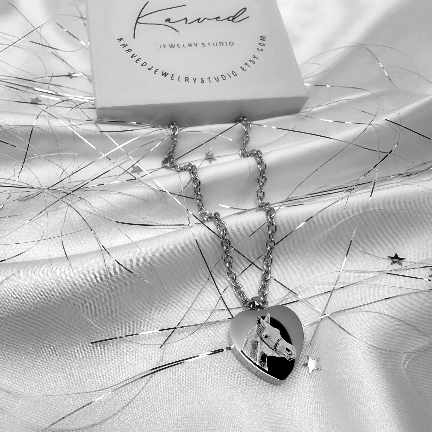 Personalized heart-shaped pet cremation urn necklace engraved with a custom horse portrait, displayed with Karved Jewelry Studio gift packaging.