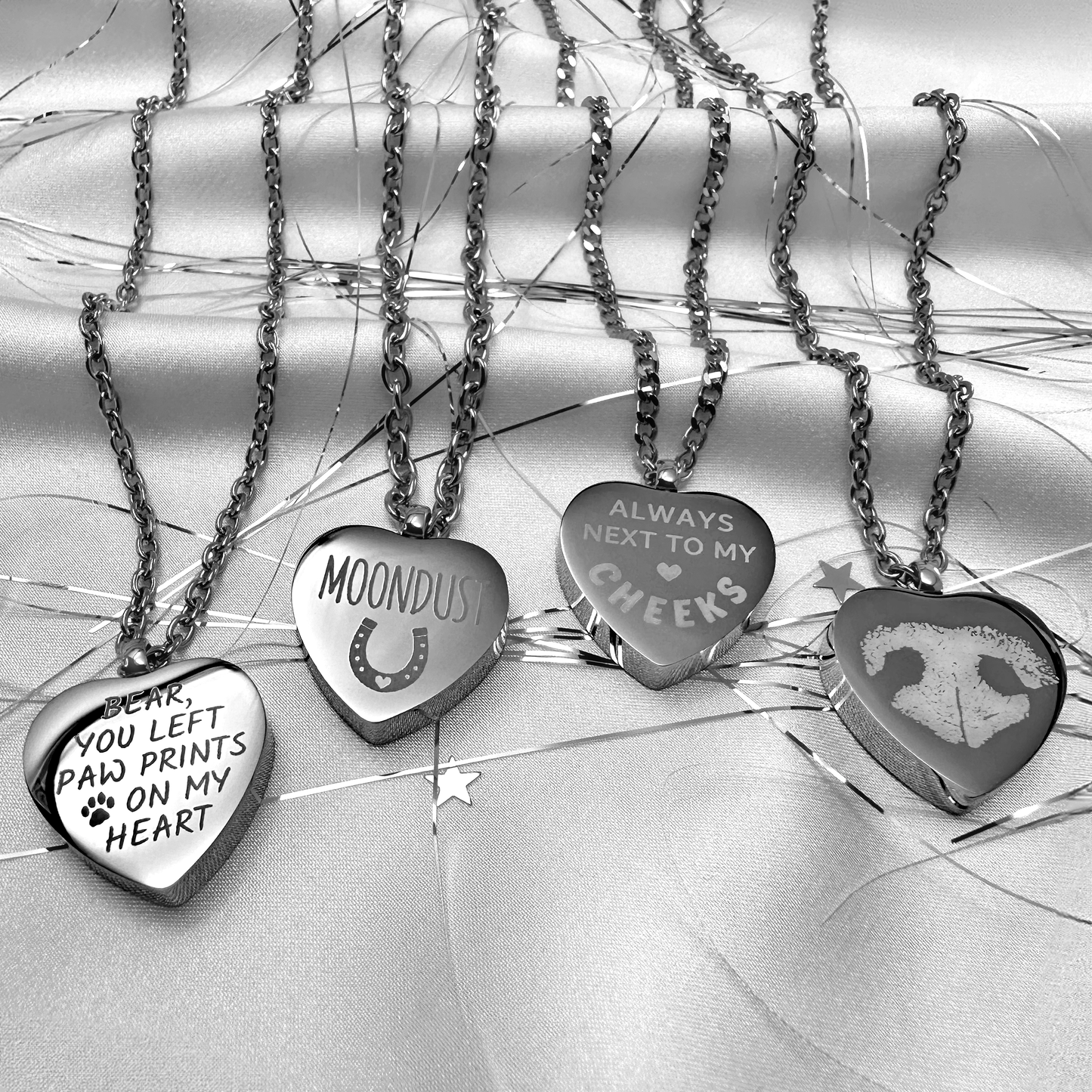 Heart-shaped pet memorial urn necklaces engraved with custom names, paw-print messages, and a pet nose print on stainless steel pendants.