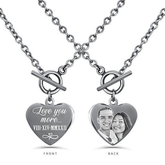 A heart pendant necklace shown on a white background, displaying the custom engraving on front and back. The front side has a personalized message and a date, engraved in Roman numerals, and the back side has a custom photo.