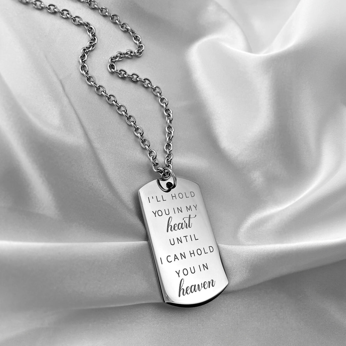 Memorial dog tag necklace displayed on satin with “I’ll hold you in my heart until I can hold you in heaven” message