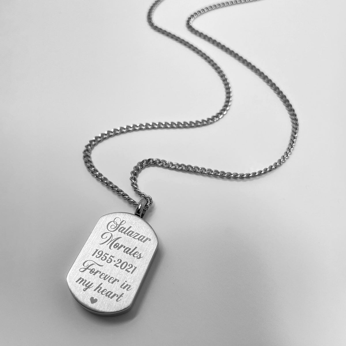 Small dog tag urn necklace with personalized memorial message engraved on the back