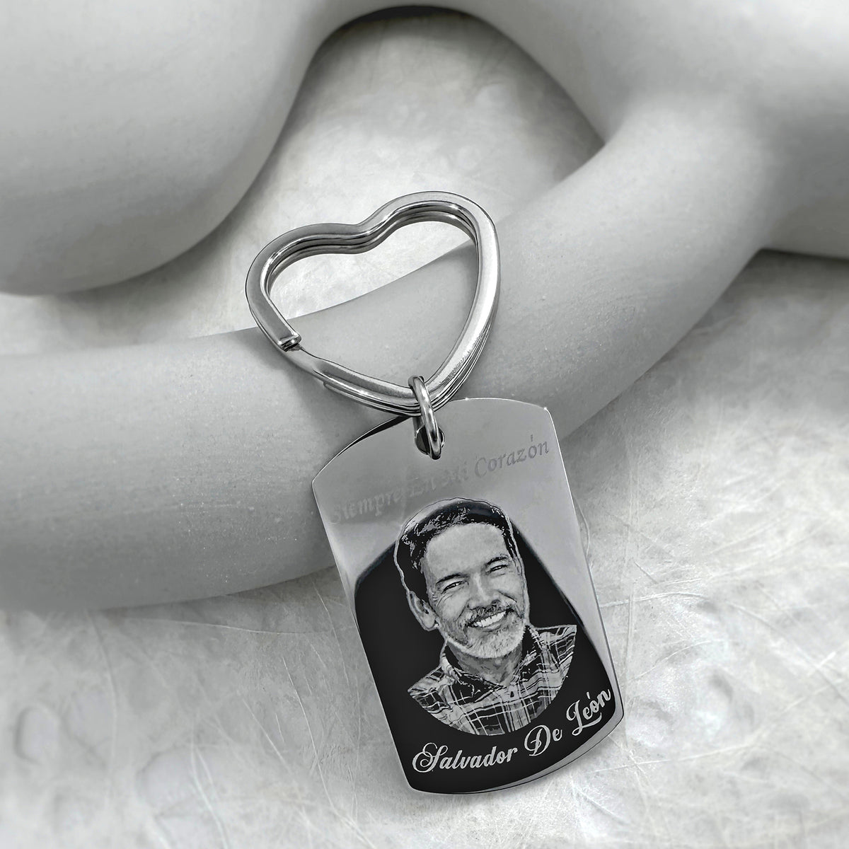 Custom memorial photo dog tag keychain with heart-shaped keyring and portrait engraving displayed in a soft lifestyle setting
