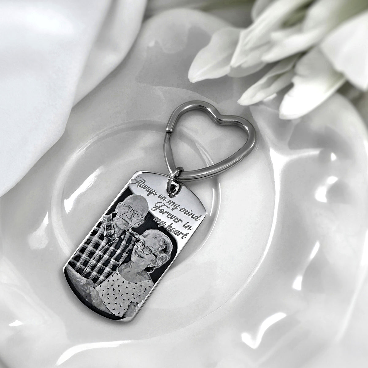 Custom portrait memorial dog tag keychain displayed on a white dish with personalized photo engraving