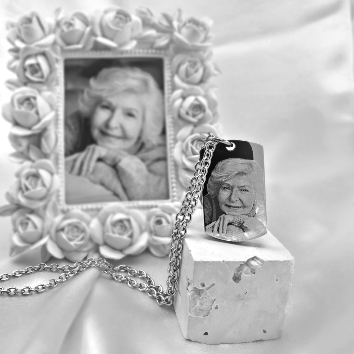 Personalized memorial photo dog tag urn necklace with custom portrait picture engraving displayed beside a framed photo 