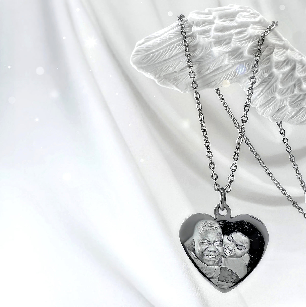 Personalized memorial heart necklace with custom photo engraving displayed on soft satin