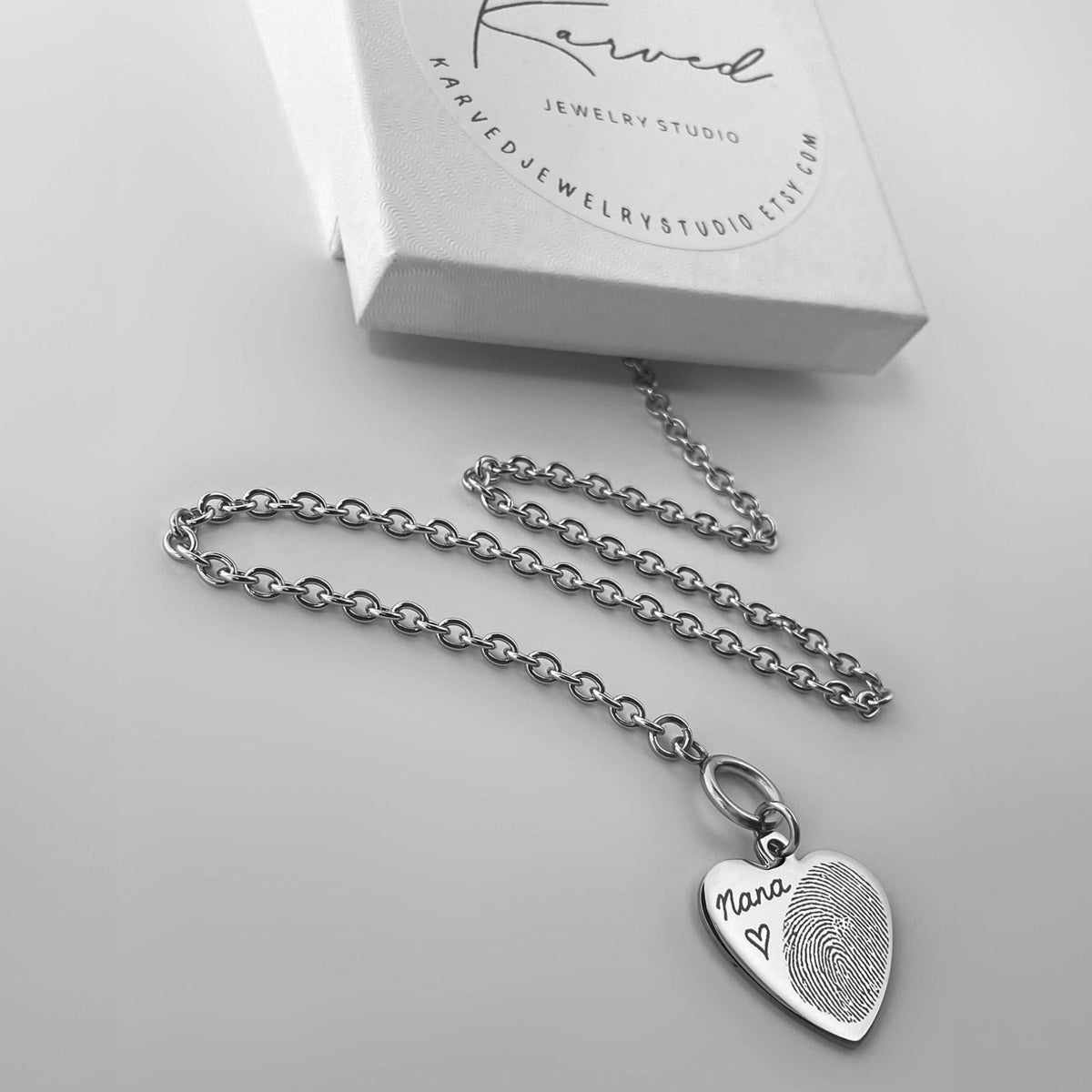A silver toggle clasp heart-shaped pendant choker necklace engraved with an actual personalized fingerprint and handwriting design.