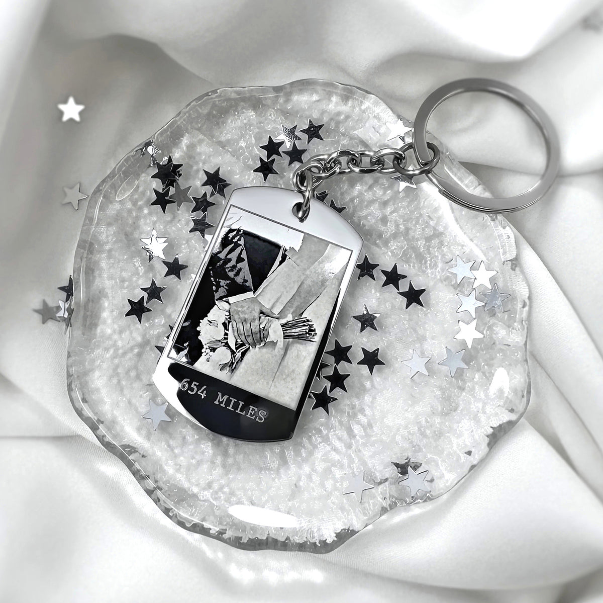 Custom long-distance relationship dog tag keychain with photo and mileage displayed in a styled setting with star accents