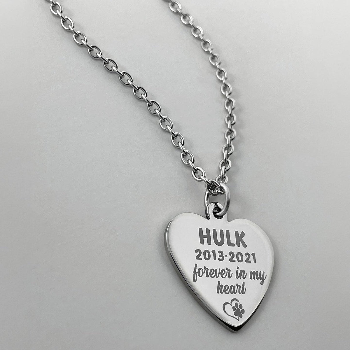 Pet memorial heart necklace engraved with pet name, dates, paw print, and personalized remembrance message