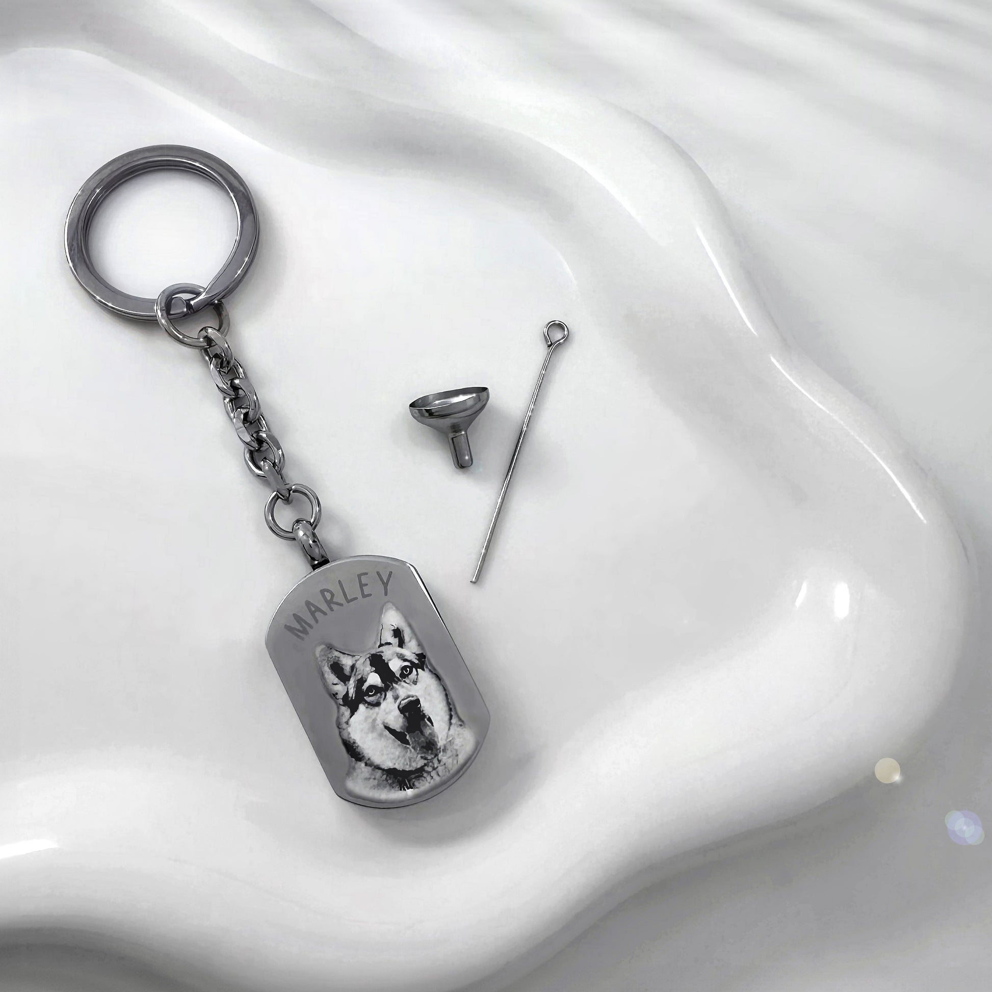 Personalized pet photo urn keychain displayed with the included funnel and filling pin.