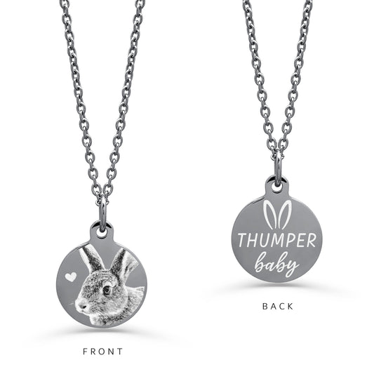 A silver round pendant necklace on a white background, displaying FRONT and BACK engraving design. The front shows a detailed personalized bunny rabbit portrait with a small heart, and the back shows the text custom name design with bunny ears at the top.