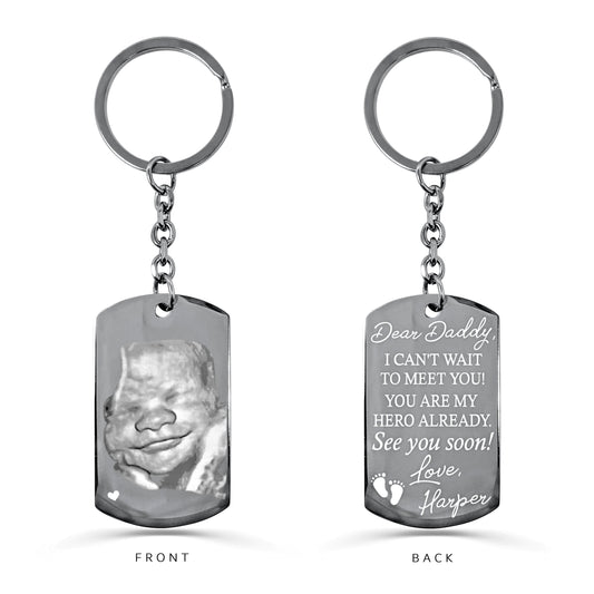 Custom sonogram dog tag keychain with round keyring featuring ultrasound photo on the front and a personalized pregnancy announcement message for Dad on the back