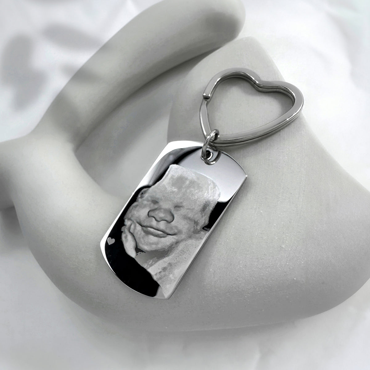 Personalized ultrasound photo dog tag keychain with heart-shaped keyring displayed in a soft lifestyle setting